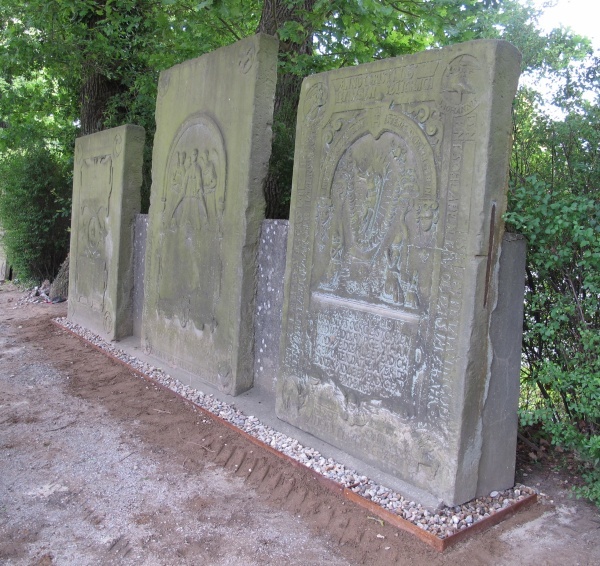 Aufgestellte Grabplatten an der Ostseite des Friedhofes. Vorn der Grabstein Timman von 1626