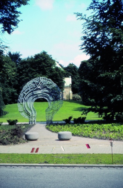Erster Anonymer Urnenhain in Hamburg Ohls-dorf, eingerichtet 1975, mit dem Tor von Klaus Bösselmann, das "Werden, Sein, Vergehen" symbolisiert (Historisches Foto, Archiv des Förderkreises Ohlsdorfer Friedhof)